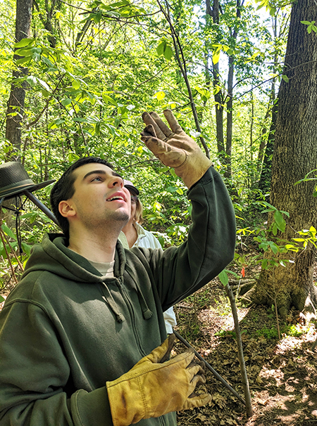 Scout looks at colonial bottle glass found during the merit badge program